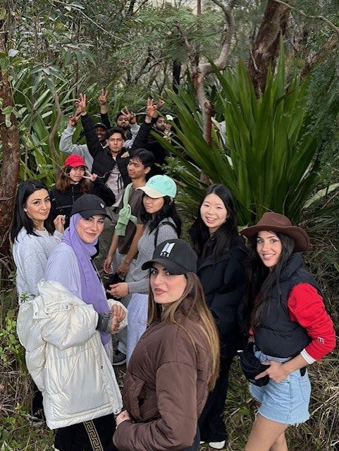 A group of students trekking through a trail in the bush